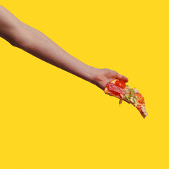 a woman's hand holds a piece of pizza. yellow background
