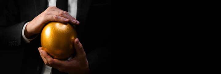 Golden egg in hands of elegant businessman as symbol of guaranteed success, profit or wealth.