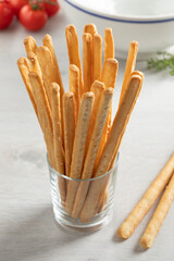 Glass with fresh baked traditional Italian bread sticks close up