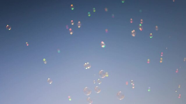 shiny soap bubbles floating in the air under the blue sky. happy childhood, summer entertainment