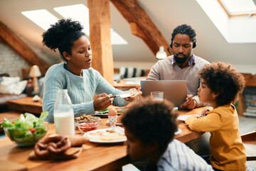 African American family having breakfast at dining table at home.