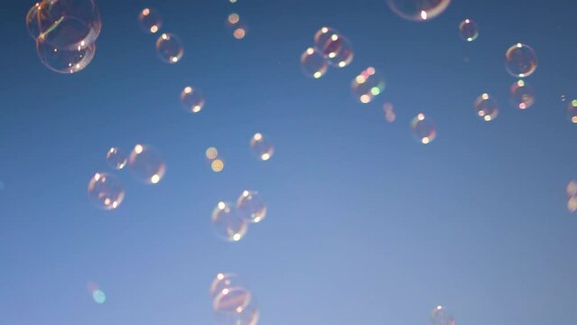 shiny soap bubbles floating in the air under the blue sky. happy childhood, summer entertainment