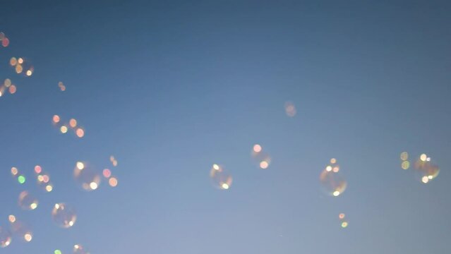 shiny soap bubbles floating in the air under the blue sky. happy childhood, summer entertainment