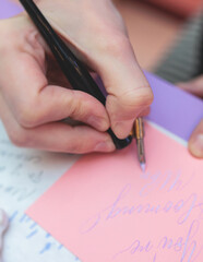 Process of calligraphy handwriting with an ink fountain pen feather, calligrapher practicing...