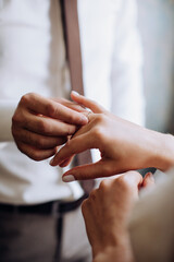 Groom puts a wedding ring on the bride’s finger