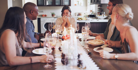 Awesome friends keep the laughter flowing. Shot of a group of young friends having a festive meal together at home.