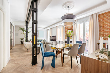 Living room with oak herringbone wall flooring, decorative glass and wood furniture and blue velvet...