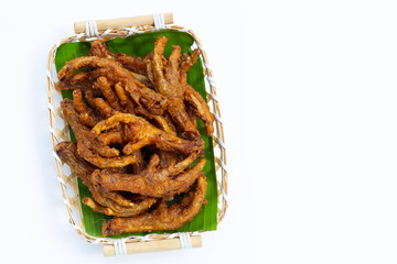 Fried chicken feet in bamboo basket on white background.