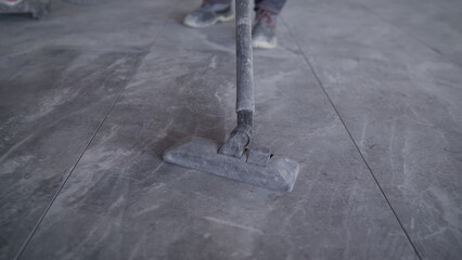Laying ceramic tiles on the floor and cleaning up debris after installation. Cleaning up debris...