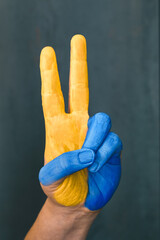 peace symbol with the fingers of the hand painted in the colors of ukraine