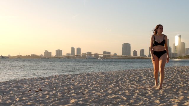 Young woman wearing a bikini at the beach on sunset over Miami