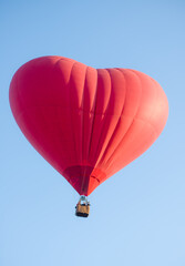 Obraz premium hot air balloon floating in the sky big red hot air balloon in the shape of a big heart for love and world peace
