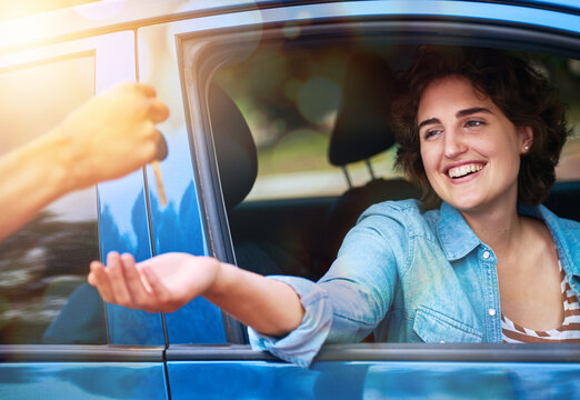 Brand new car. Lifes good. Cropped shot of a man handing a young woman the keys to her new car.