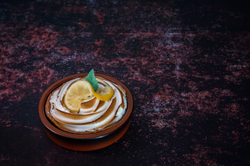 Traditional french lemon tart on a dark rusty table. close-up shot. View from above . copy space for text