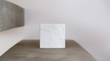Carrara marble cube on a concrete step block; copy space composition