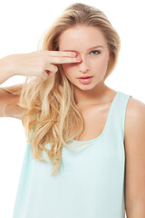 Obraz premium Im cutting you off.... A pretty young woman snipping her fingers over her eyes while isolated on white.