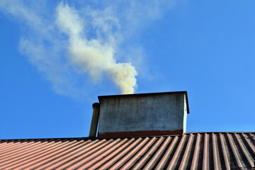 Dark smoke from the chimney of an apartment building during heating season