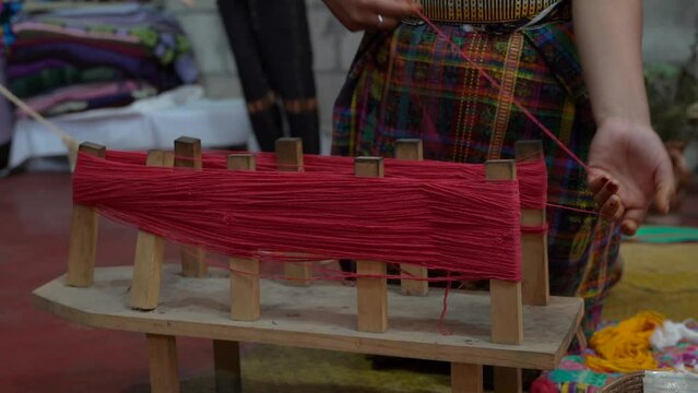 Closeup view of a Guatemalan Indigenous woman working in a traditional and typical handmade textile 