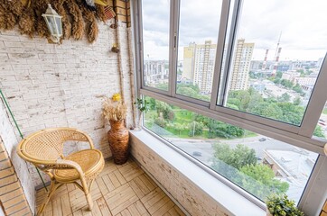 Cozy balcony in summer with armchair and flowers 