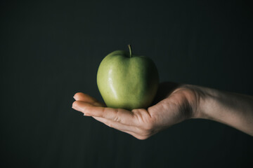 green apple in hands of woman