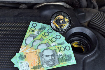 Australian dollar money currency and the thick, greasy yellow motor oil under oil cap
