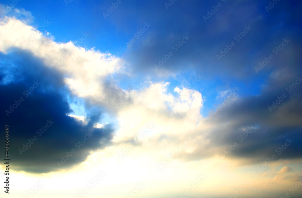 Wall mural Blue sky in Penna San Giovanni covered by two dark clouds on the left and on the right with a white glowing cloud in the middle between them