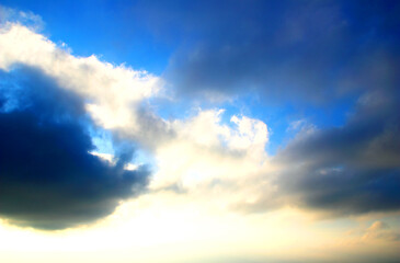 Blue sky in Penna San Giovanni covered by two dark clouds on the left and on the right with a white glowing cloud in the middle between them