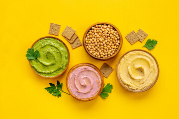 Green and purple hummus with spinach and beets in bowls, top view