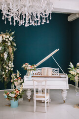 Grand piano, flowers in studio. Piano surrounded by flowers.