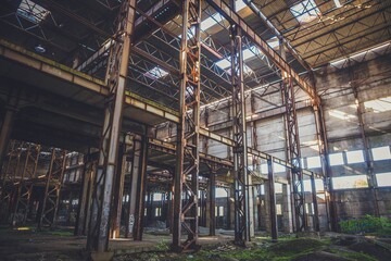 The sun's rays break through the roof of an abandoned warehouse 