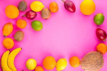 Fototapeta na wymiar Fresh fruitage on pink background. Coconut, tangerines, bananas