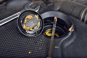 The thick, greasy yellow motor oil under oil cap as signs and symptom of a blown head gasket