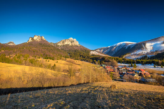 Rural landscape with mountain peaks on background in early spring. The Stefanova village in Vratna valley of The Mala Fatra national park, Slovakia, Europe.