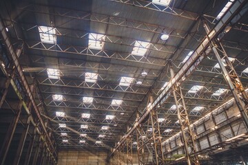 The sun's rays break through the roof of an abandoned warehouse 