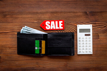 Sale tag and wallet with banknotes and bank cards