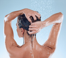 Good hygiene leads to a great lifestyle. Studio shot of a young woman taking a shower against a blue background.