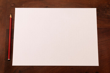 Blank paper and pencil on a wooden table.