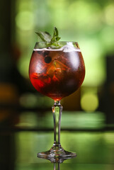 Alcohol red cocktail drink on blur green background