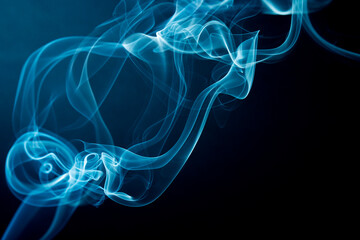 Abstract beautiful smoke against black background.  Swirling movement of smoke. Toxic movement of white and blue smoke on black background.  