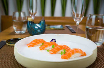 Delicious premium salmon nigiri on white handmade plate