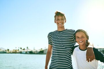 Brothers for life. Cropped portrait of two young brothers standing outside with a lagoon in the...