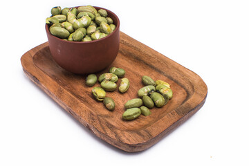 salted bean seeds in a wooden bowl. Isolated on white background.