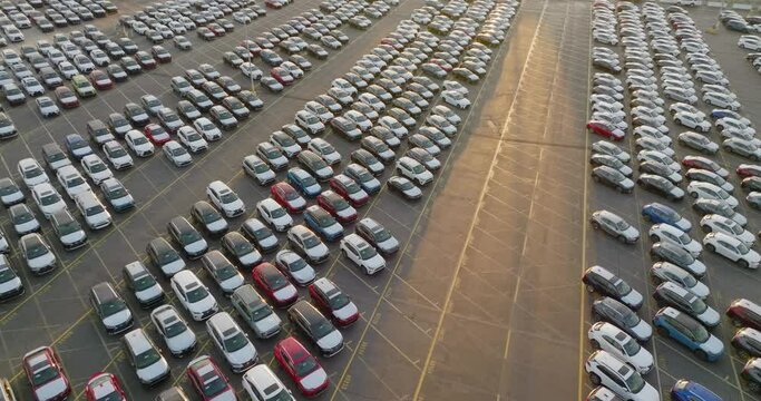 Aerial view of rows of new cars parked in parking lot. New vehicles lined up for automotive dealer import and export