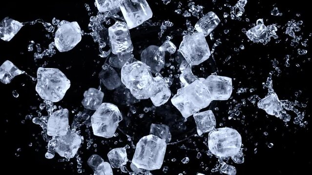 Super slow motion shot of rotating exploded Ice Cubes and splashing water on black at 1000fps.