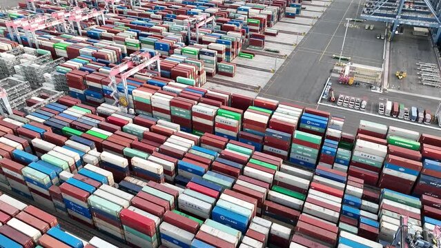 Aerial view of shipping containers and cranes loading cargo ready for export and import of trade goods at the port.