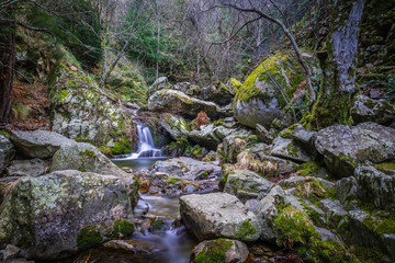 Mountain river with huge stones covered with moss in the outdoor park of Poço do Inferno, Serra da Estrela - Portugal