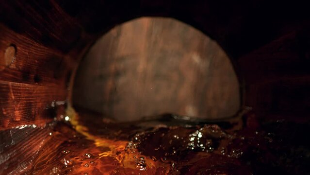 Super Slow Motion Detail Shot of Waving Whiskey in Wooden Barrel at 1000fps.