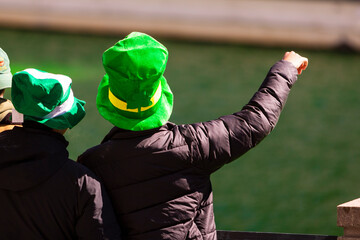 Two people, maybe a couple, both wearing green hats for St Patricks Day.