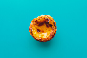Top view of typical Portuguese dessert pastry Past&eacute;is de Nata - Portuguese egg custard tart, with a blue background
