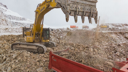 tracked excavator loading the material in a truck